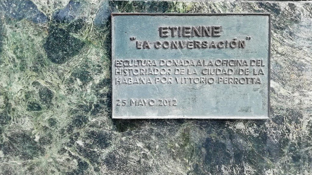 Placa de bronce colocada sobre el Zócalo de la estatua La Conversación en la Plaza de San Francisco de Asís en La Habana