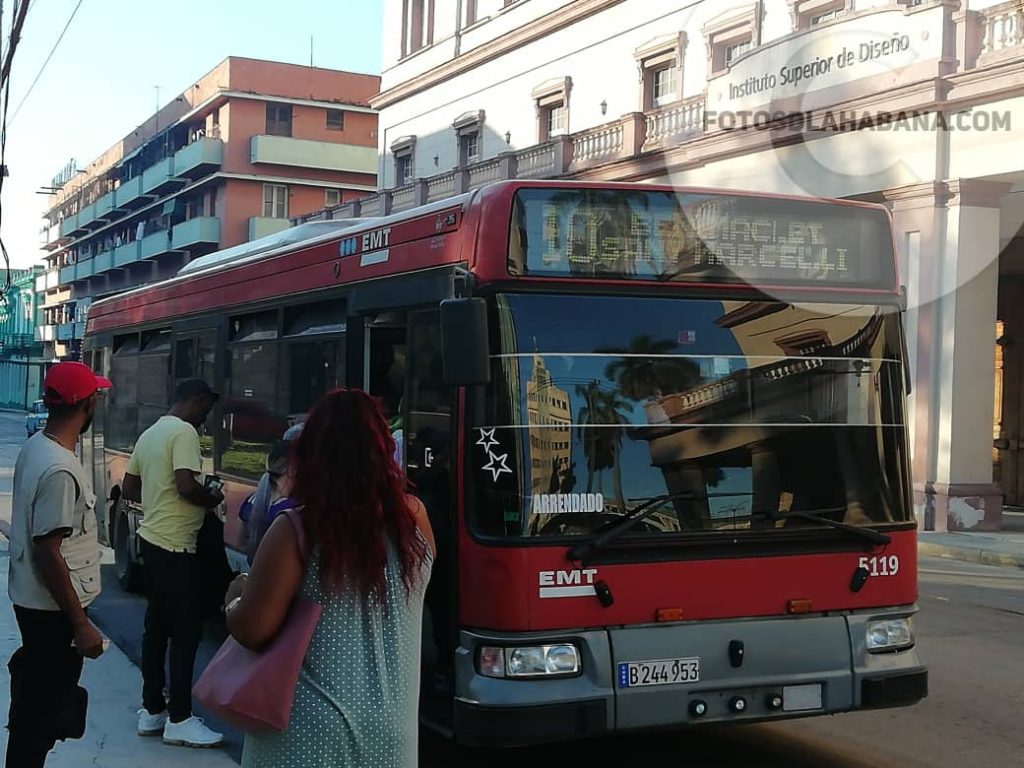 Uno de los ómnibus arrendados en La Habana carga pasaje en la calle Belascoaín